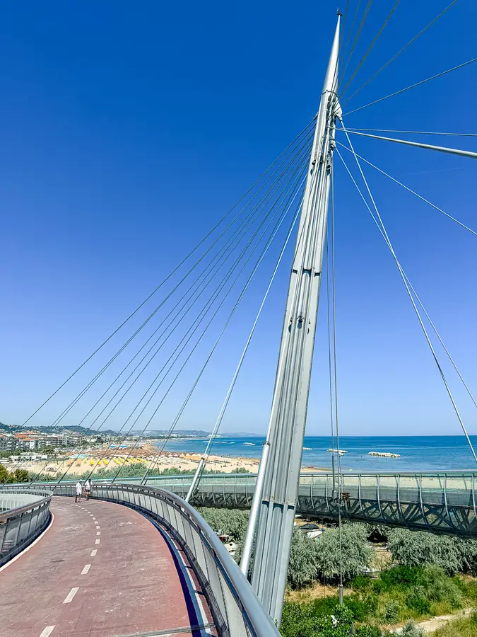 Le funi bianche del Ponte del Mare contro il cielo blu, con la spiaggia sullo sfondo